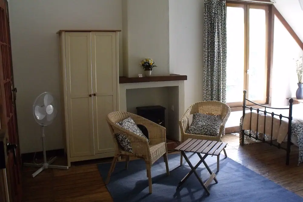 Elizabeth's Room sitting area with wicker chairs and garden views, Le Moulin St Blaise