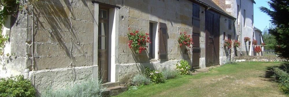Stone facade of Moulin St Blaise with red geraniums, Chahaignes, Sarthe, France