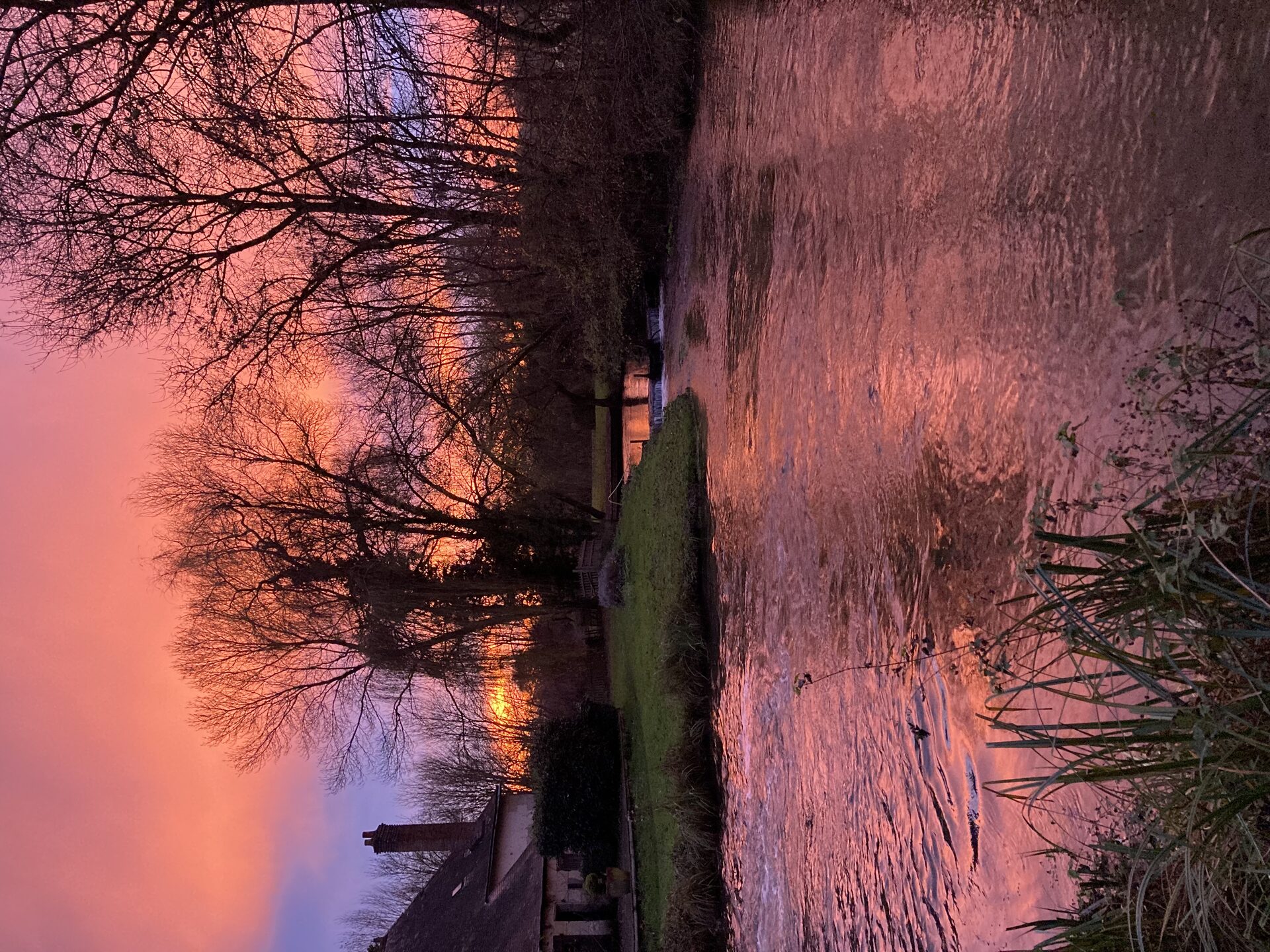 Dramatic winter sunset reflected in the La Veuve at Moulin St Blaise, Sarthe, France