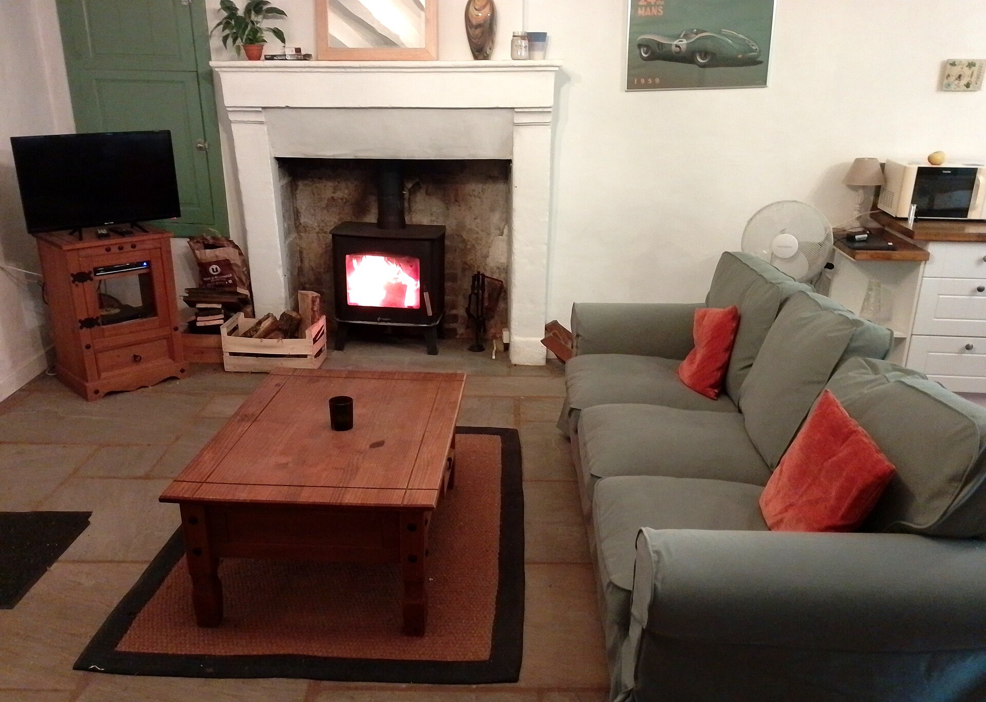 Cosy lounge of Gite La Maison du Frere with wood burning stove, stone fireplace and comfortable sofas, Moulin St Blaise