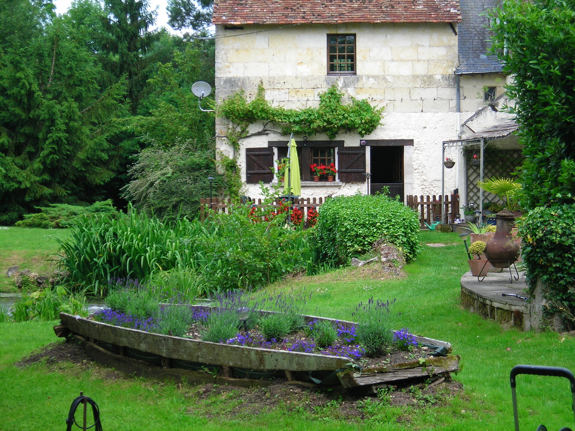 Old wooden boat planted with lavender in the gardens of Moulin St Blaise watermill